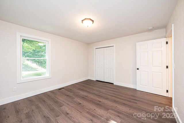 2448 Alfred Hartley Rd, Lenoir, NC 28645 - unfurnished bedroom featuring dark wood-type flooring, baseboards, and a closet