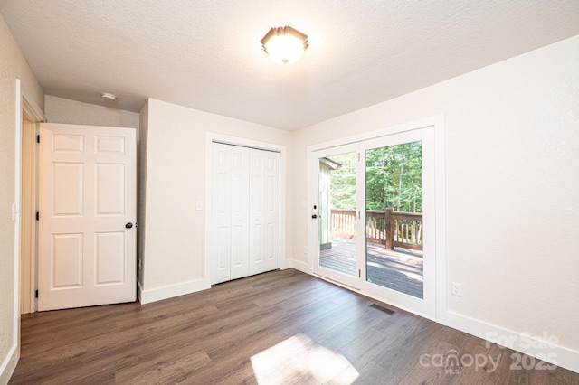 2448 Alfred Hartley Rd, Lenoir, NC 28645 - unfurnished bedroom featuring dark wood-style flooring, access to outside, baseboards, and a textured ceiling