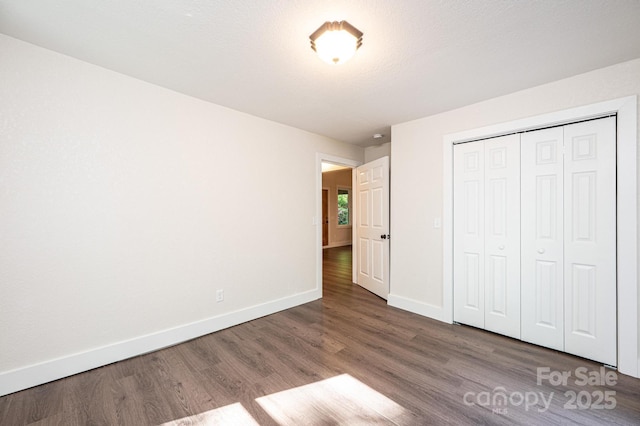 2448 Alfred Hartley Rd, Lenoir, NC 28645 - unfurnished bedroom with baseboards, wood finished floors, and a closet
