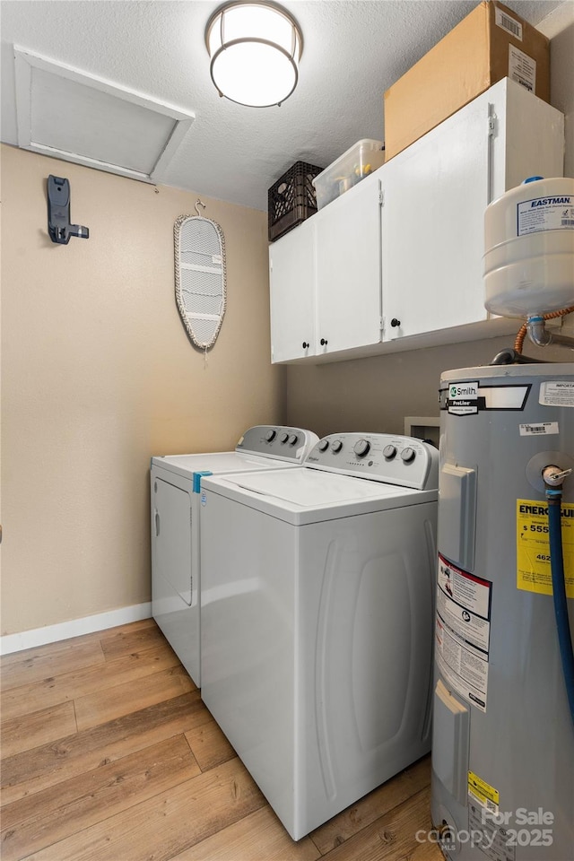 381 Mountain View St, Forest City, NC 28043 - laundry area with electric water heater, washer and clothes dryer, cabinet space, light wood finished floors, and baseboards