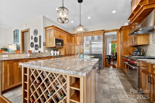 2160 Valle Cay Dr, Vilas, NC 28692 - kitchen with built in appliances, wall chimney range hood, stone tile floors, backsplash, and recessed lighting