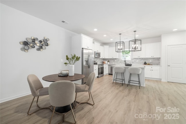 2313 Stallings Rd, Harrisburg, NC 28075 - dining space featuring recessed lighting, light wood-type flooring, a chandelier, and baseboards