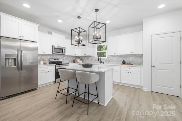 2313 Stallings Rd, Harrisburg, NC 28075 - kitchen with stainless steel appliances, tasteful backsplash, white cabinets, a kitchen bar, and recessed lighting