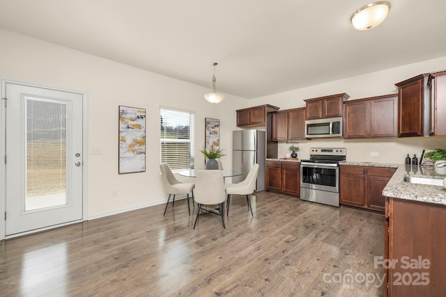 5160 Thomasville Dr Unit 123, Belmont, NC 28012 - kitchen featuring stainless steel appliances, light wood-type flooring, hanging light fixtures, and light stone counters