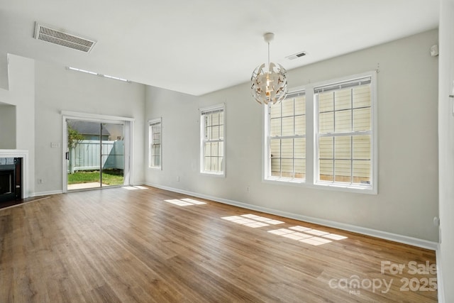 8605 Sawleaf Ct, Charlotte, NC 28215 - unfurnished living room with a chandelier, baseboards, wood finished floors, and a high end fireplace