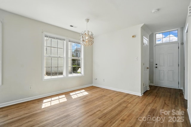 8605 Sawleaf Ct, Charlotte, NC 28215 - entrance foyer featuring a chandelier, light wood-style floors, baseboards, and plenty of natural light