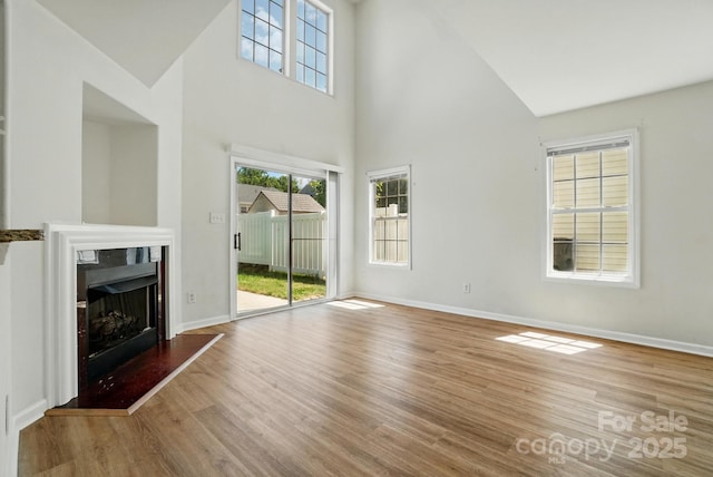 8605 Sawleaf Ct, Charlotte, NC 28215 - unfurnished living room with a high ceiling, wood finished floors, a high end fireplace, and baseboards