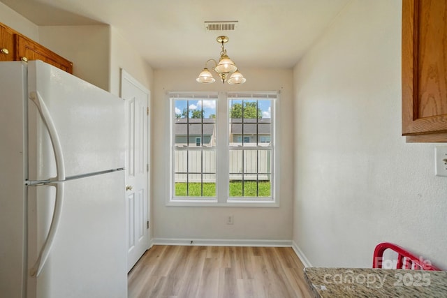 8605 Sawleaf Ct, Charlotte, NC 28215 - unfurnished dining area featuring light wood-style floors, a chandelier, and baseboards