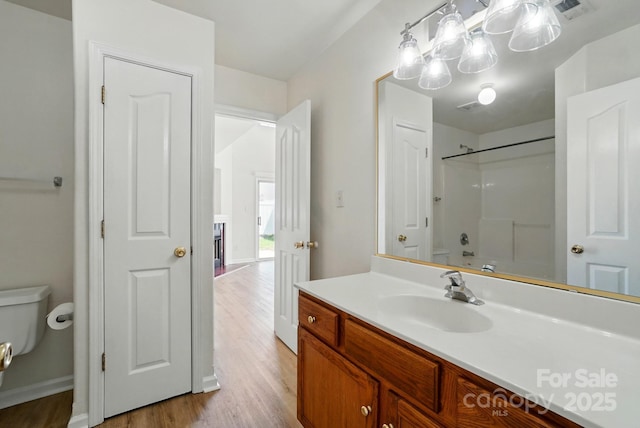 8605 Sawleaf Ct, Charlotte, NC 28215 - full bathroom featuring toilet, wood finished floors, vanity, baseboards, and shower / washtub combination