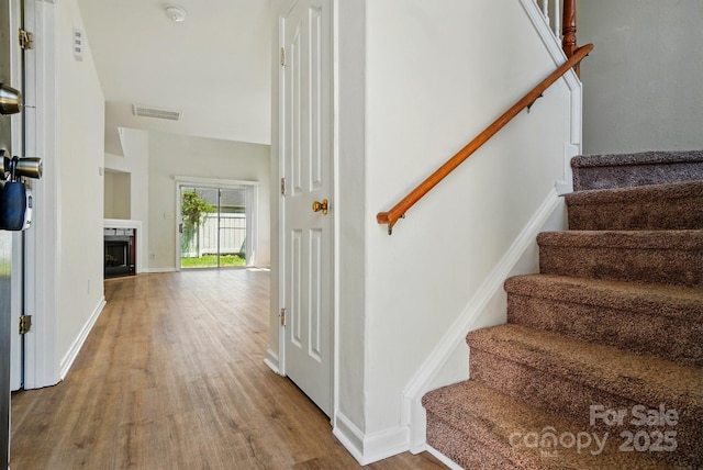 8605 Sawleaf Ct, Charlotte, NC 28215 - staircase featuring wood finished floors, baseboards, and a fireplace