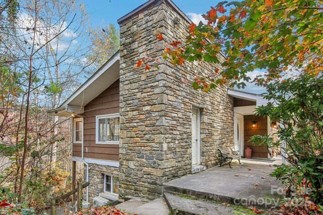 231 Highlands Loop, Maggie Valley, NC 28751 - view of side of home with stone siding and a chimney