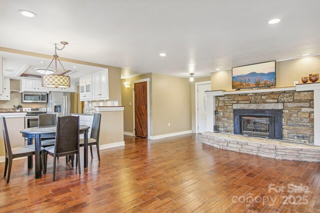 231 Highlands Loop, Maggie Valley, NC 28751 - dining space featuring wood finished floors, baseboards, a stone fireplace, and recessed lighting