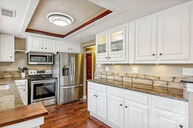 231 Highlands Loop, Maggie Valley, NC 28751 - kitchen featuring appliances with stainless steel finishes, a raised ceiling, white cabinetry, and glass insert cabinets