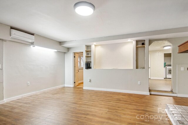 231 Highlands Loop, Maggie Valley, NC 28751 - finished below grade area with a wall mounted air conditioner, light wood-style floors, and baseboards