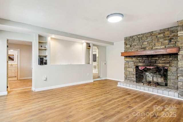 231 Highlands Loop, Maggie Valley, NC 28751 - unfurnished living room with baseboards, light wood-type flooring, a fireplace, and a sink