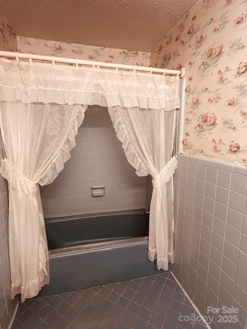 6714 Old Shelby Rd, Vale, NC 28168 - full bathroom with shower / bath combo, wallpapered walls, a wainscoted wall, a textured ceiling, and tile walls