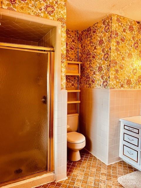 6714 Old Shelby Rd, Vale, NC 28168 - full bathroom with wallpapered walls, a wainscoted wall, toilet, a stall shower, and tile walls