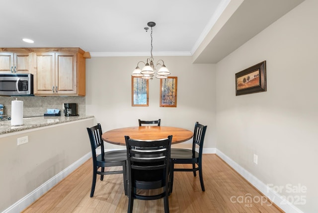 408 Bowling Park Rd, Asheville, NC 28803 - dining room featuring a chandelier, light wood-style flooring, baseboards, and ornamental molding
