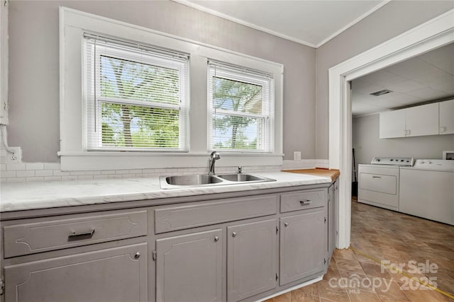 725 W Graham St, Shelby, NC 28150 - kitchen with separate washer and dryer, a sink, light countertops, and crown molding