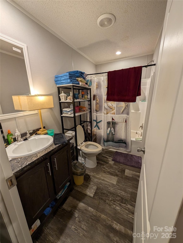 8827 Spring Meadow Dr, Hickory, NC 28601 - bathroom featuring vanity, wood finished floors, a textured ceiling, toilet, and shower / bath combo