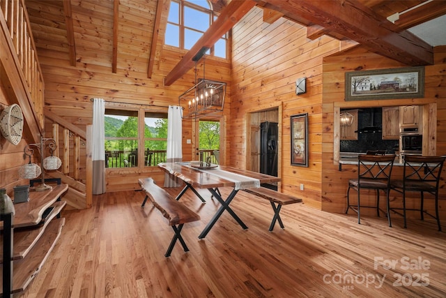 101 Trinity Dr, Clyde, NC 28721 - dining area featuring wood walls, light wood finished floors, beamed ceiling, and high vaulted ceiling