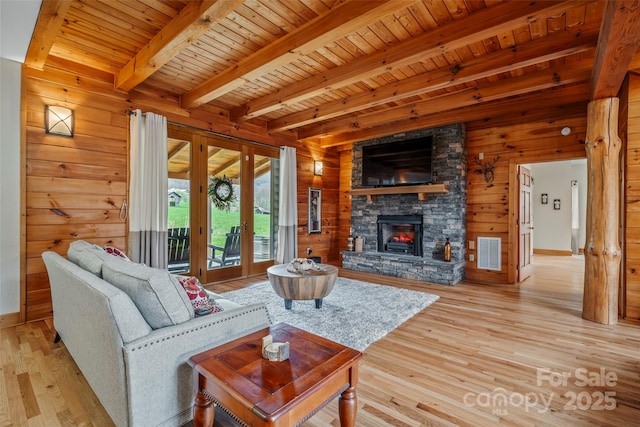 101 Trinity Dr, Clyde, NC 28721 - living area with wood walls, wood ceiling with exposed beams, light wood finished floors, french doors, and a fireplace