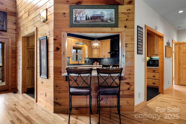 101 Trinity Dr, Clyde, NC 28721 - kitchen featuring light wood-style flooring, a breakfast bar, backsplash, black microwave, and recessed lighting