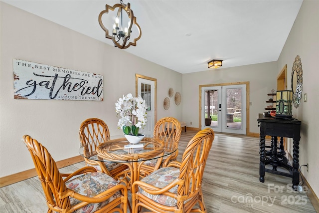 101 Trinity Dr, Clyde, NC 28721 - dining area with french doors, light wood finished floors, a chandelier, and baseboards