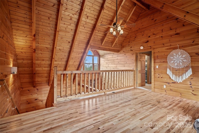 101 Trinity Dr, Clyde, NC 28721 - unfurnished room featuring wood walls, wooden ceiling with exposed beams, an upstairs landing, wood finished floors, and ceiling fan