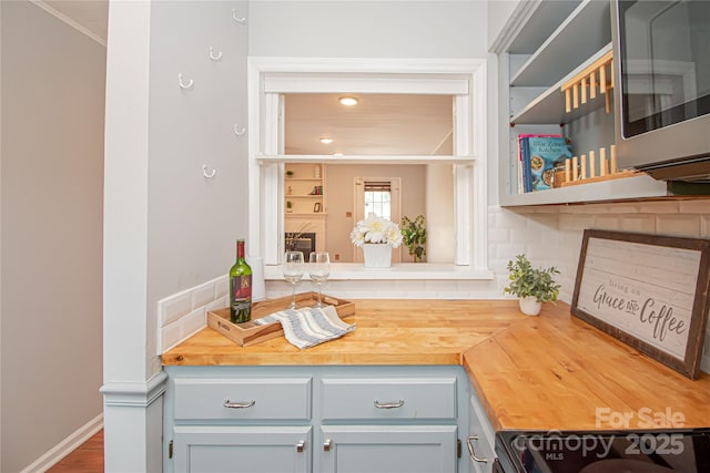 10945 Winterbourne Ct, Charlotte, NC 28277 - kitchen with butcher block counters, crown molding, stainless steel microwave, range, and open shelves