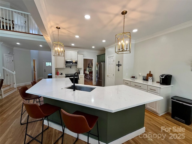 4230 Berry Hill Ct, Concord, NC 28025 - kitchen with stainless steel appliances, crown molding, a chandelier, light wood finished floors, and a breakfast bar area