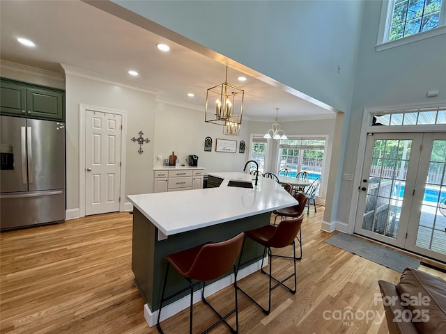 4230 Berry Hill Ct, Concord, NC 28025 - kitchen with stainless steel fridge, crown molding, a chandelier, light countertops, and light wood finished floors