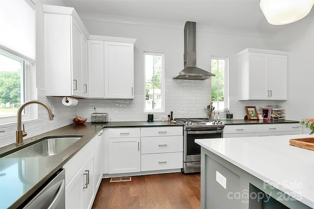 2600 Palm Ave, Charlotte, NC 28205 - kitchen with wall chimney range hood, stainless steel appliances, a sink, dark wood finished floors, and decorative backsplash