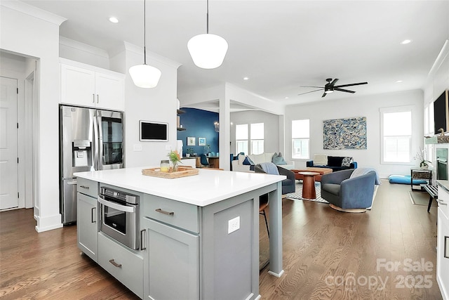 2600 Palm Ave, Charlotte, NC 28205 - kitchen with appliances with stainless steel finishes, a kitchen island, light countertops, a ceiling fan, and a kitchen bar