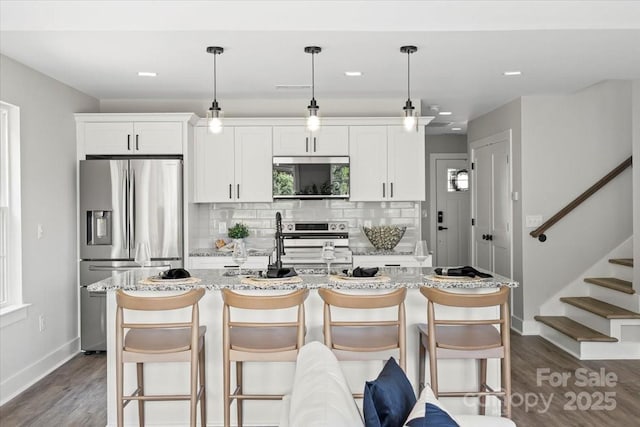 2906 Swicegood Rd, Linwood, NC 27299 - kitchen featuring stainless steel appliances, a kitchen island with sink, baseboards, dark wood finished floors, and tasteful backsplash