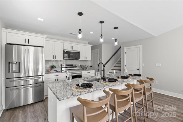 2906 Swicegood Rd, Linwood, NC 27299 - kitchen with appliances with stainless steel finishes, a sink, dark wood-style floors, white cabinets, and baseboards