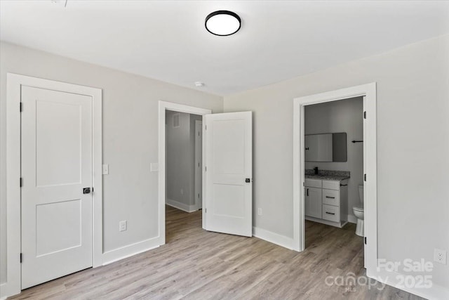 2906 Swicegood Rd, Linwood, NC 27299 - unfurnished bedroom featuring light wood-style flooring, baseboards, and ensuite bathroom