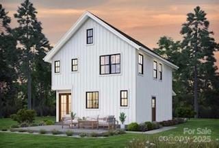 0000 Trull Hinson Rd Unit 4, Wingate, NC 28174 - back of house at dusk featuring board and batten siding, a lawn, and a patio area