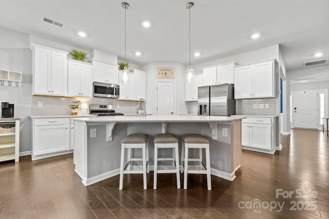 12637 Belmont Mansion Dr, Charlotte, NC 28273 - kitchen featuring stainless steel appliances, backsplash, white cabinetry, light countertops, and recessed lighting