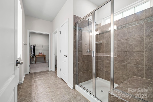 12637 Belmont Mansion Dr, Charlotte, NC 28273 - bathroom featuring a stall shower, a walk in closet, tile patterned floors, and baseboards