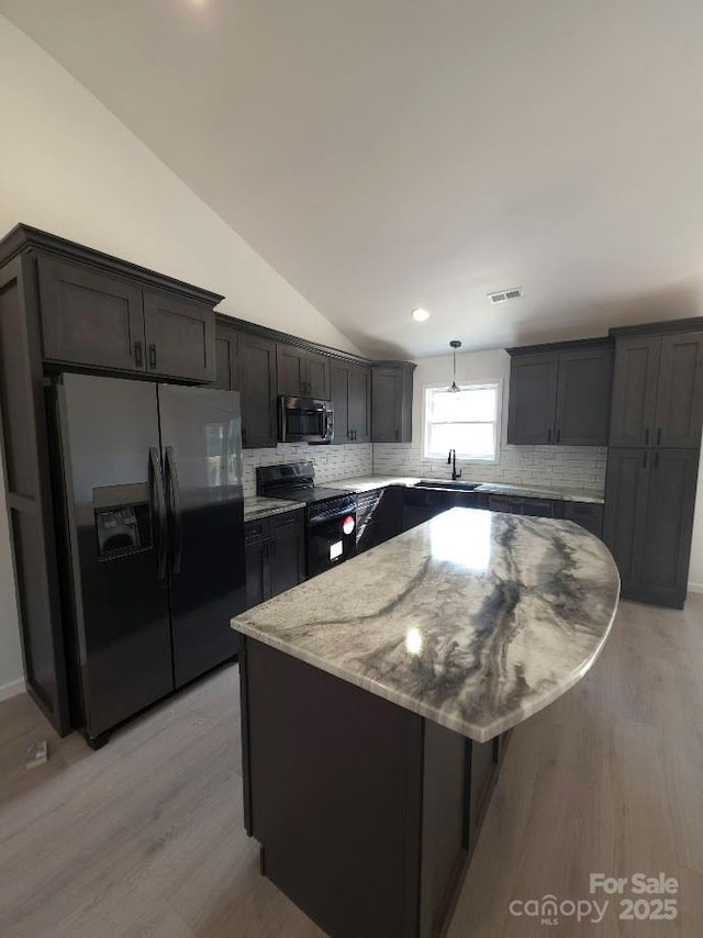 4364 Grover Pl, Granite Falls, NC 28630 - kitchen with stainless steel appliances, vaulted ceiling, light stone counters, decorative backsplash, and light wood-style floors