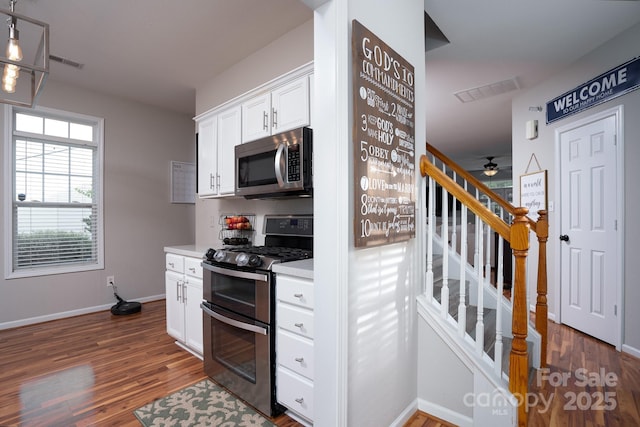 12719 Walking Stick Dr, Charlotte, NC 28278 - kitchen featuring stainless steel appliances, dark wood-style flooring, light countertops, and white cabinetry