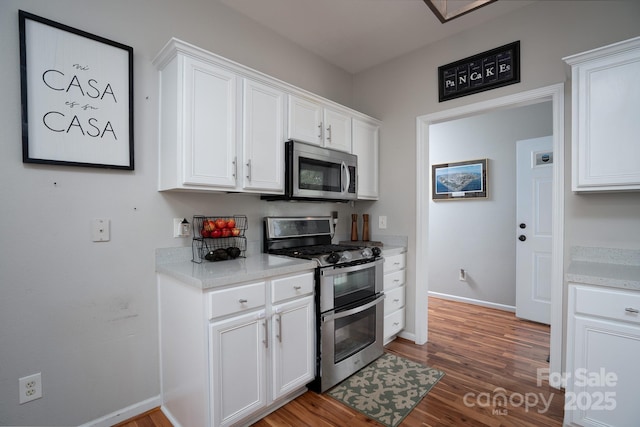 12719 Walking Stick Dr, Charlotte, NC 28278 - kitchen featuring stainless steel appliances, wood finished floors, white cabinets, and baseboards