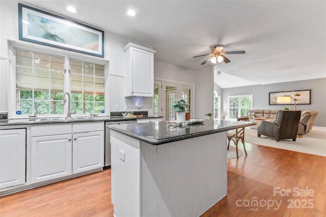 5233 Fairvista Dr, Charlotte, NC 28269 - kitchen with a sink, stainless steel dishwasher, a ceiling fan, white cabinets, and light wood finished floors