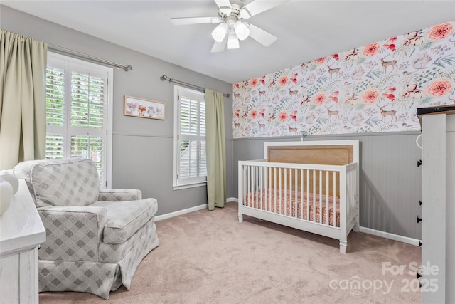 5233 Fairvista Dr, Charlotte, NC 28269 - carpeted bedroom with a wainscoted wall, multiple windows, a nursery area, baseboards, and ceiling fan