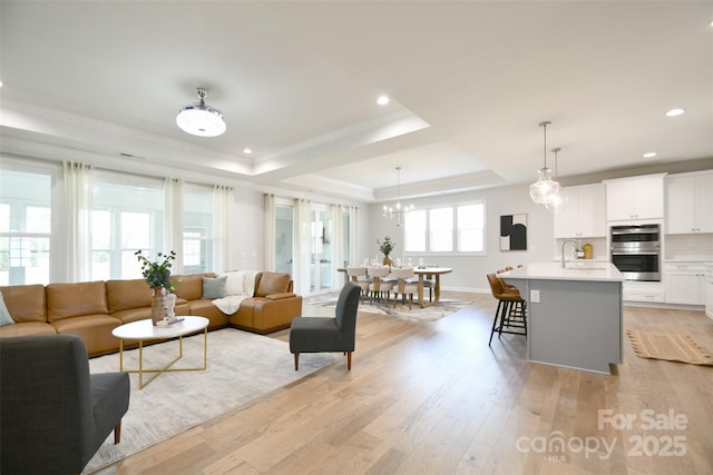 3924 Dahlia Dr, Harrisburg, NC 28075 - living room with a raised ceiling, light wood-style flooring, crown molding, baseboards, and recessed lighting