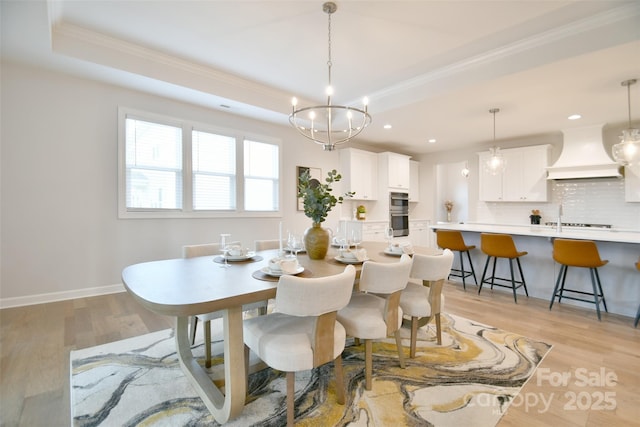 3924 Dahlia Dr, Harrisburg, NC 28075 - dining space featuring a tray ceiling, ornamental molding, light wood-style floors, baseboards, and a chandelier