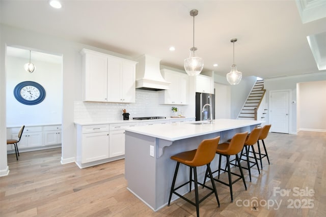 3924 Dahlia Dr, Harrisburg, NC 28075 - kitchen featuring custom exhaust hood, gas cooktop, a center island with sink, decorative backsplash, and recessed lighting