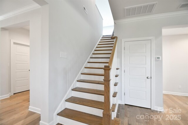 3924 Dahlia Dr, Harrisburg, NC 28075 - stairway with wood finished floors, crown molding, arched walkways, and baseboards