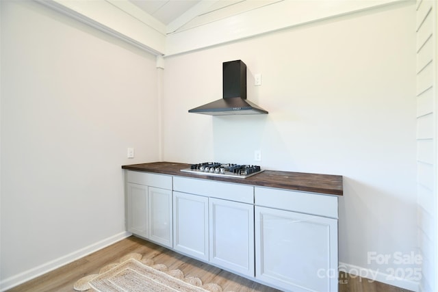 3924 Dahlia Dr, Harrisburg, NC 28075 - detailed view of wall chimney exhaust hood, wood finished floors, stainless steel gas cooktop, and baseboards